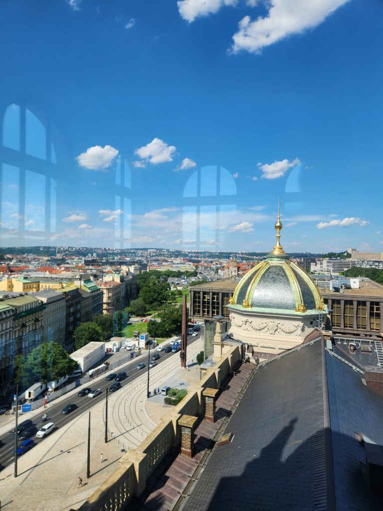 A view framed through glass and reflection from the top of the museum